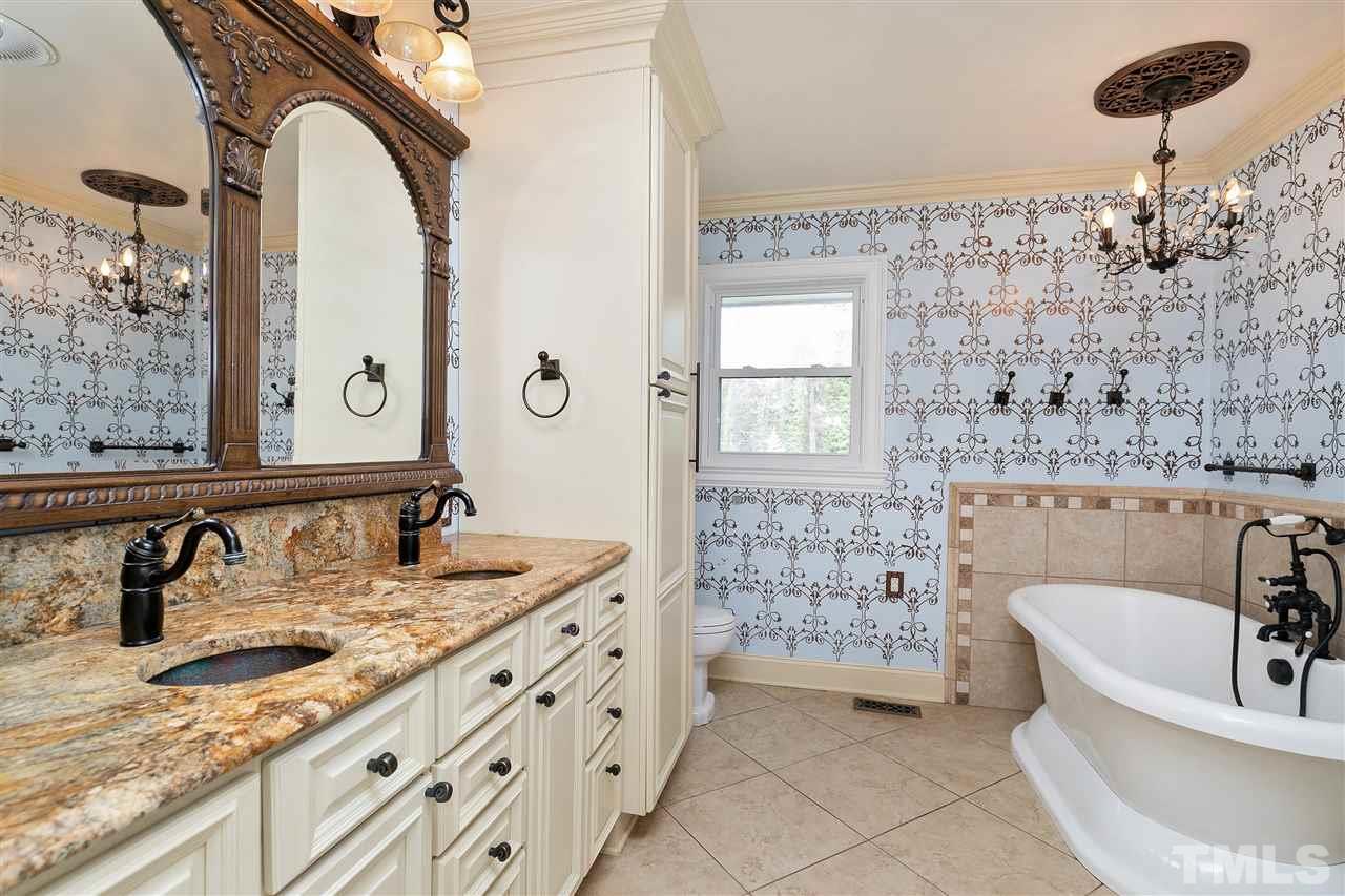 3105 Julian Drive Raleigh, NC 27604 - Photo 13 of 30 a bathroom with a granite countertop sink a mirror and bathtub