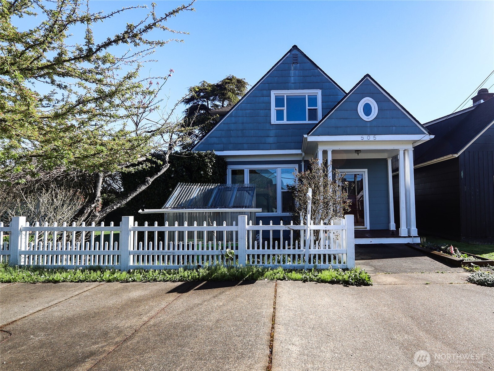 505 K Street Hoquiam, WA 98550 - Photo 1 of 40 a view of a brick house with large windows and a small yard