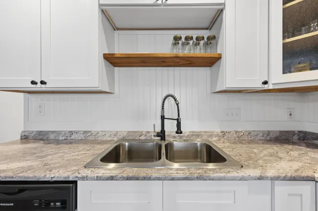a kitchen with granite countertop a sink and a stove