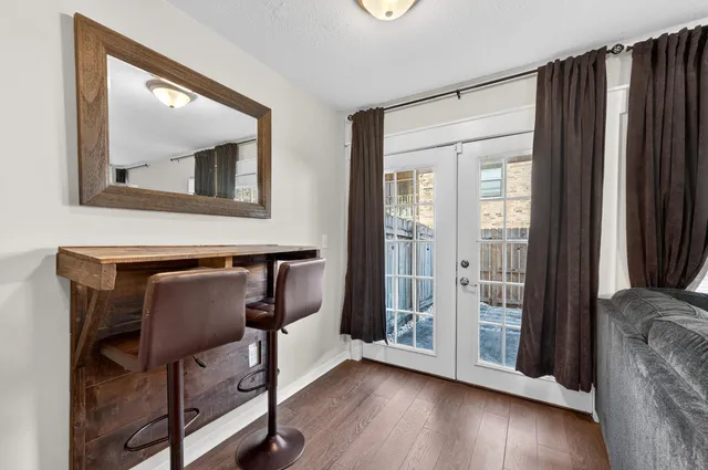a view of a hallway with wooden floor and glass door