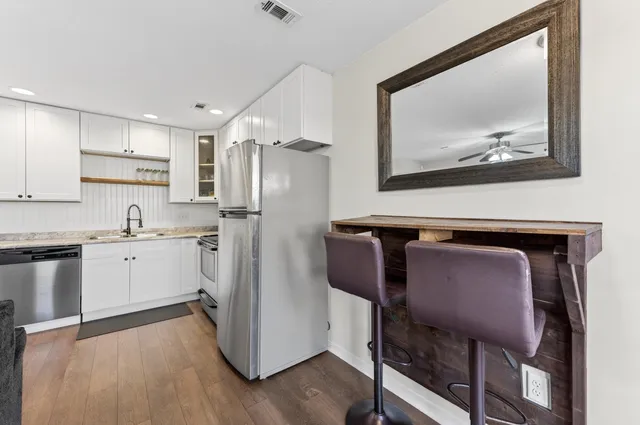 a kitchen with a refrigerator and a stove top oven