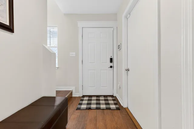 a view of a hallway with wooden floor and closet