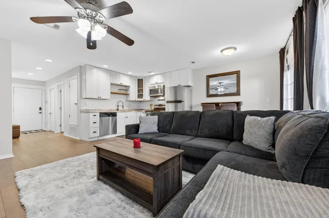a living room with furniture and kitchen view