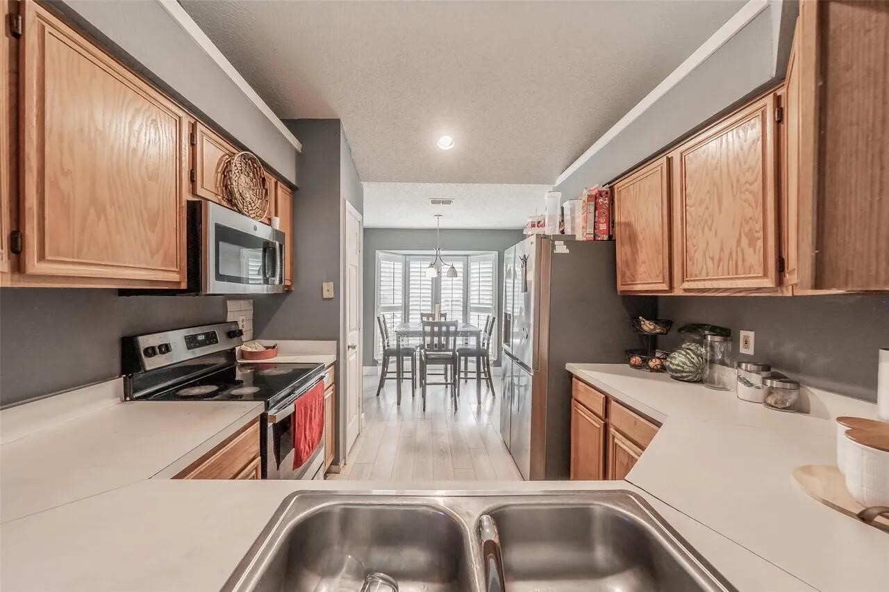 4520 Wedgecrest Drive Dallas, TX 75232 - Photo 6 of 19 a kitchen with a sink a counter top space cabinets and a stainless steel appliances