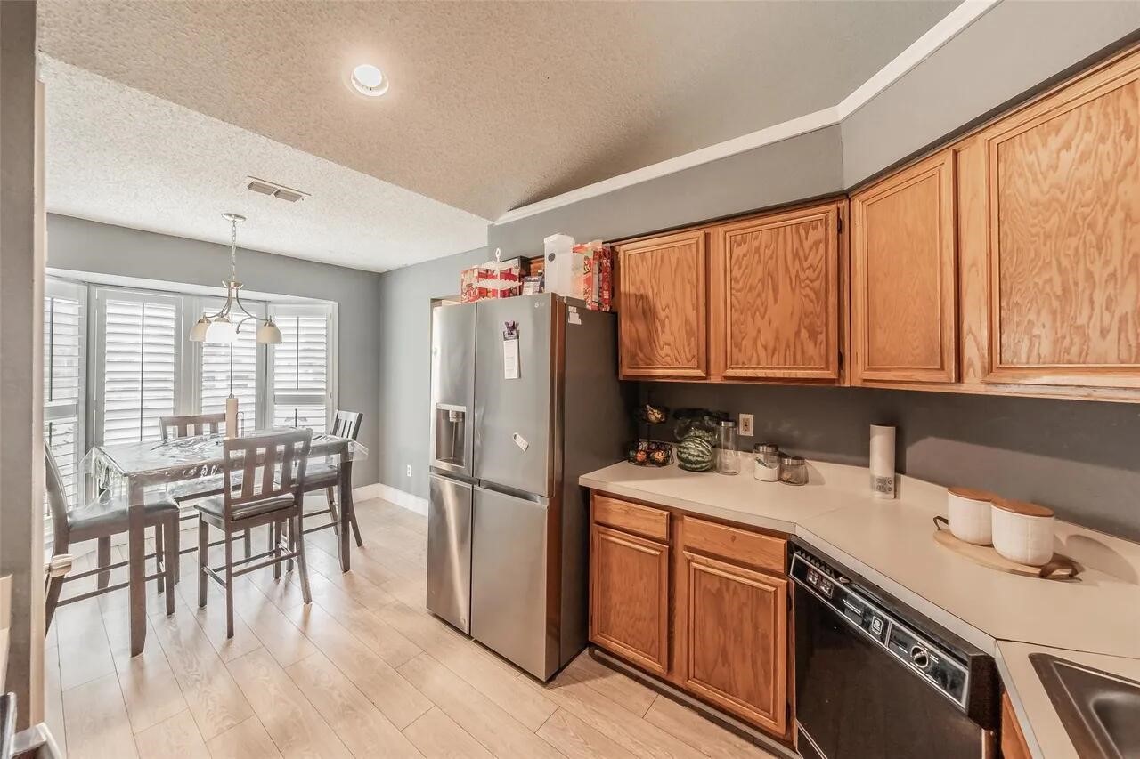 4520 Wedgecrest Drive Dallas, TX 75232 - Photo 9 of 19 a kitchen with a sink a stove a refrigerator cabinets and dining table