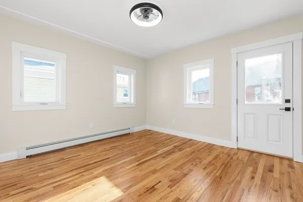 a view of empty room with wooden floor
