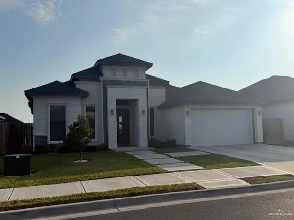 a view of a house with a yard and potted plants