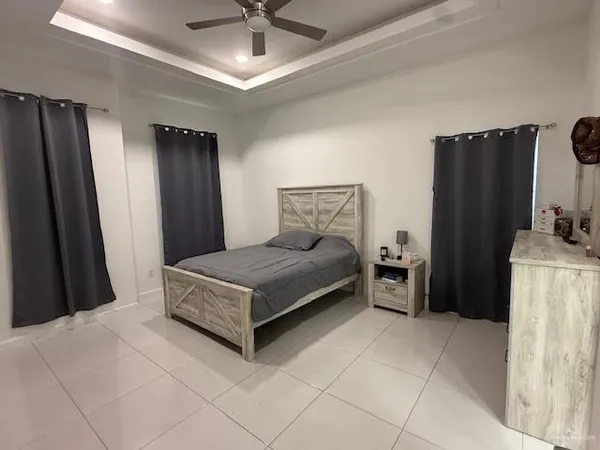 a bedroom with a bed dresser and a large window