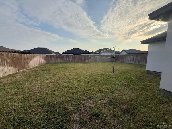a view of a house with a yard and a large tree