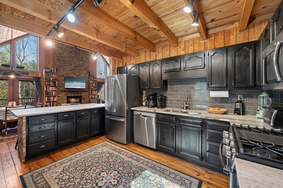 109 Carolina Cove Road Seneca, SC 29672 - Photo 13 of 45 This spacious kitchen features sleek appliances, including a gas range and oven, and a cozy fireplace nearby.