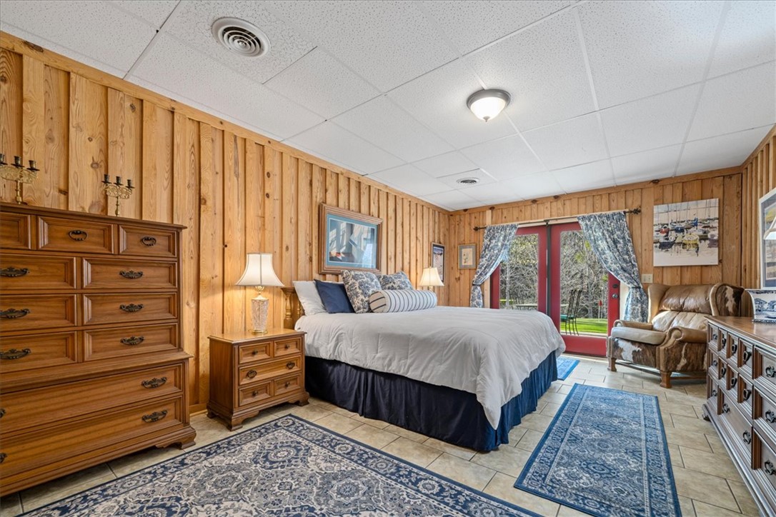 109 Carolina Cove Road Seneca, SC 29672 - Photo 28 of 45 This cozy bedroom features warm wood paneling and direct access to the outdoors.