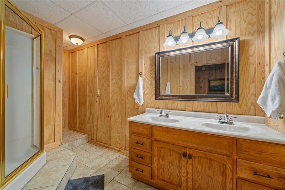 109 Carolina Cove Road Seneca, SC 29672 - Photo 30 of 45 This lower level bathroom features natural wood paneling, a double vanity, and shower.