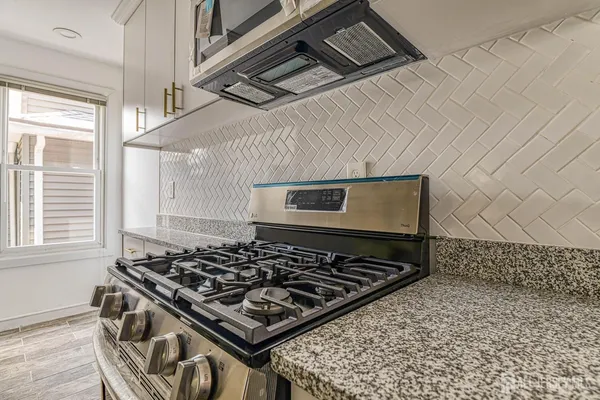 a kitchen with a stove sink and cabinets