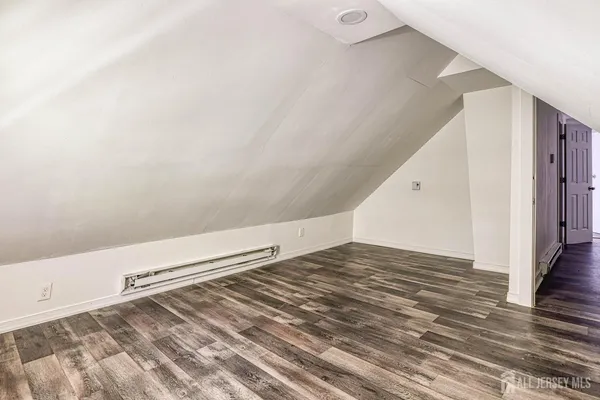 a view of a room with wooden floor and white walls