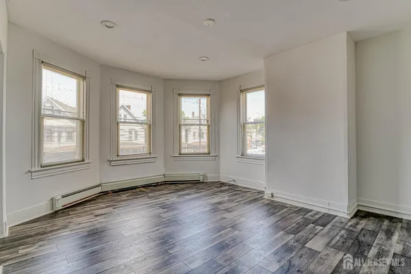 a view of empty room with wooden floor
