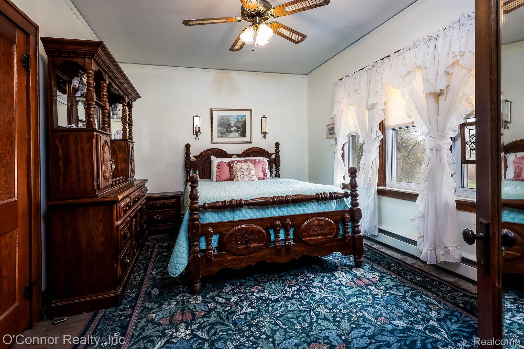 3323 Kinney Road Emmett, MI 48022 - Photo 14 of 29 Spacious room featuring patterned broadloom carpeting, a ceiling fan with integrated lighting, two windows with decorative valances, and wood-trim door frames