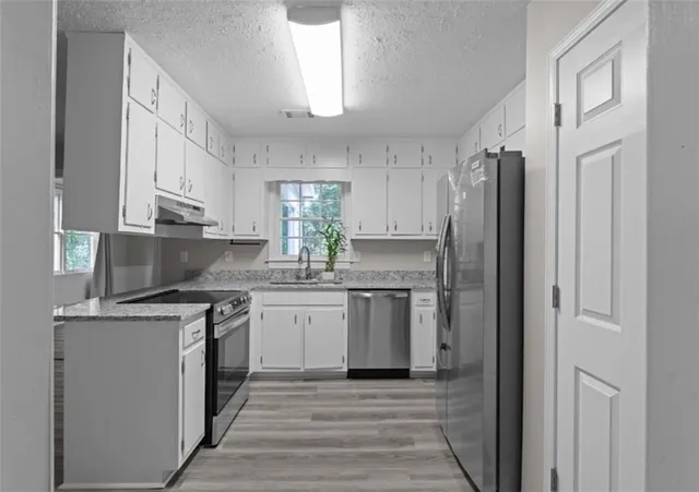 a kitchen with stainless steel appliances granite countertop a stove a refrigerator and a refrigerator