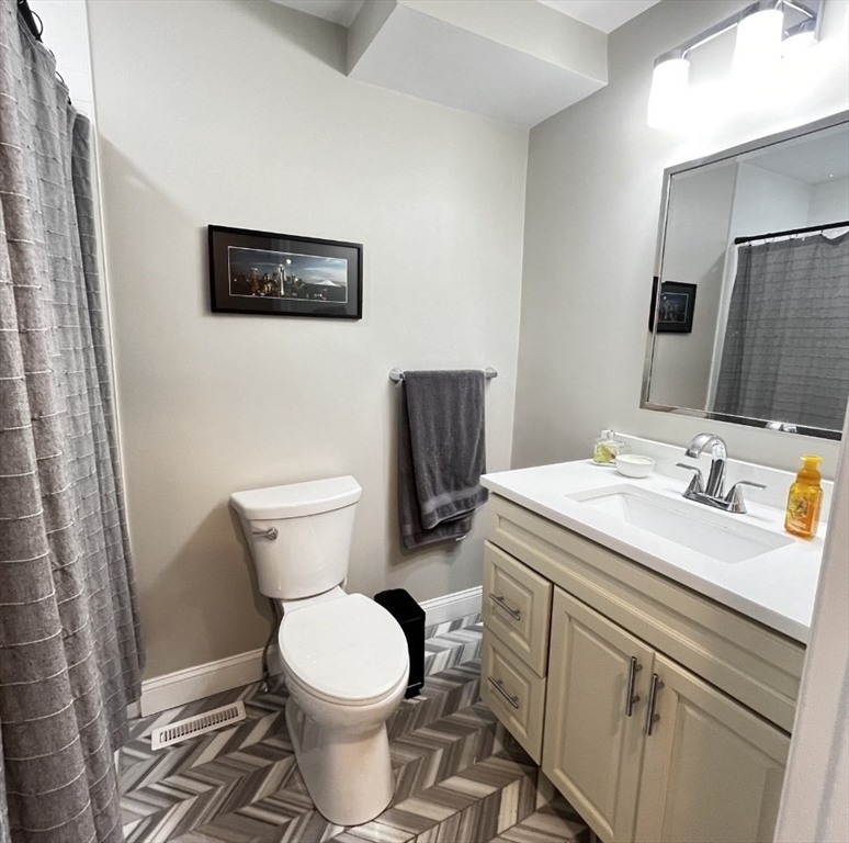 229 Maverick Street, Unit 1 Boston, MA 02128 - Photo 17 of 20 a bathroom with a sink toilet and mirror