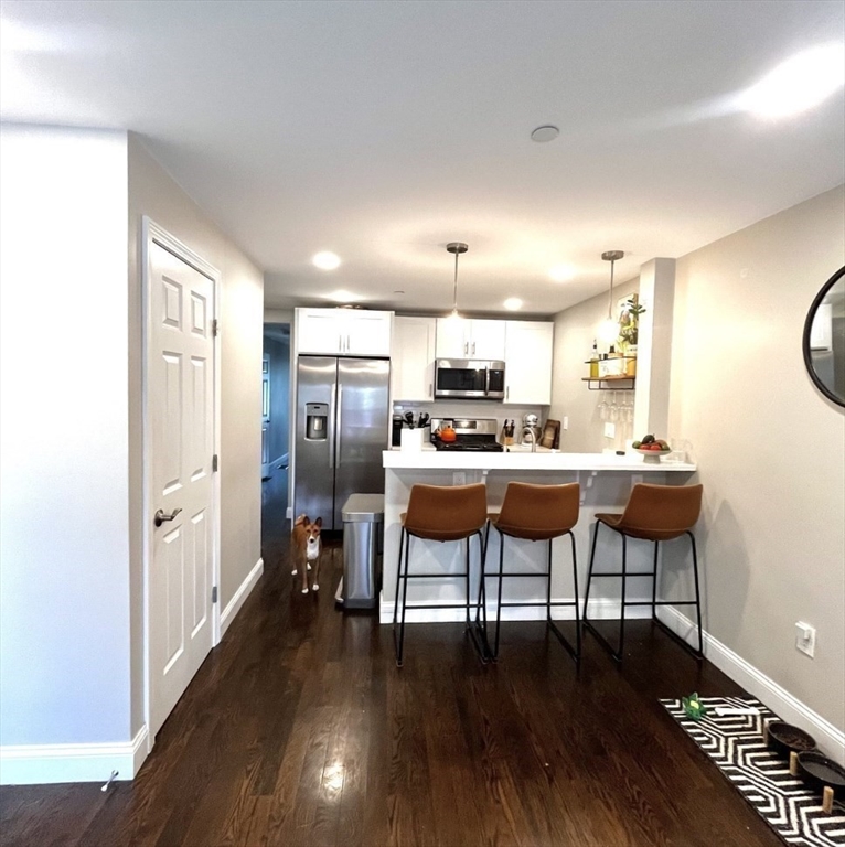 229 Maverick Street, Unit 1 Boston, MA 02128 - Photo 5 of 20 a living room with furniture and a wooden floor