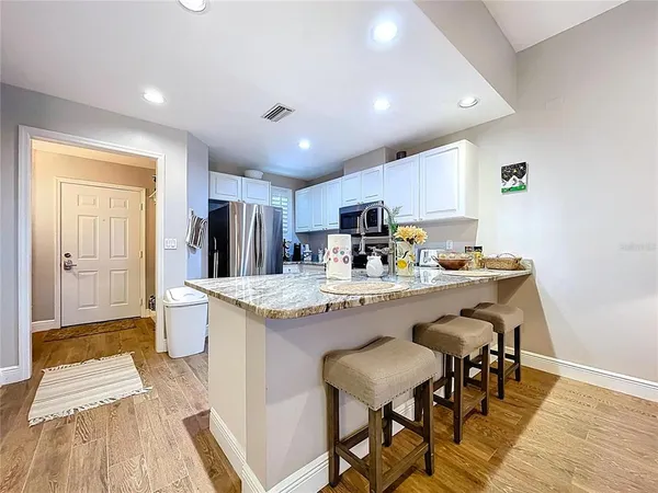 a living room with furniture kitchen view and a window