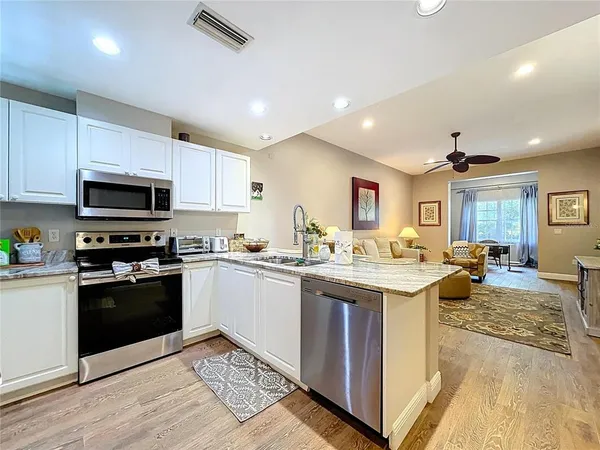a kitchen with stainless steel appliances granite countertop a refrigerator sink and stove