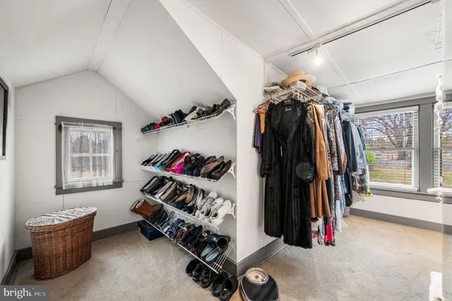 a view of walk in closet with clothes and shoes