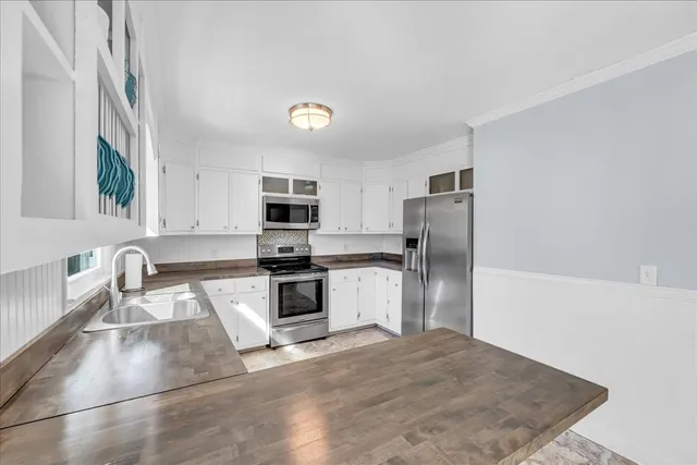 a kitchen with stainless steel appliances granite countertop a sink stove and cabinets