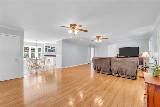 a dining room with furniture a chandelier and wooden floor
