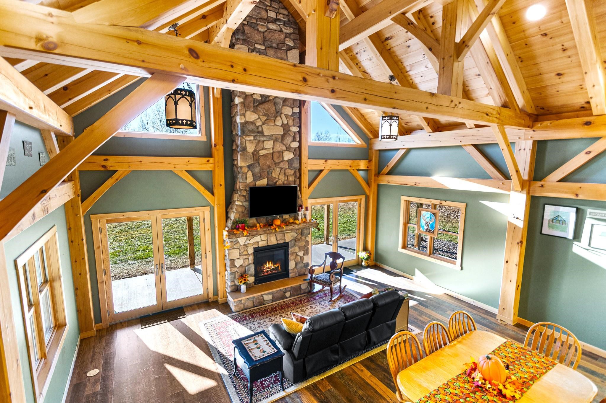 6014 Brown Road Kettle River, MN 55757 - Photo 11 of 54 Living area featuring high vaulted ceiling, hardwood / wood-style flooring, a fireplace, a wooden ceiling with exposed beams, and french doors