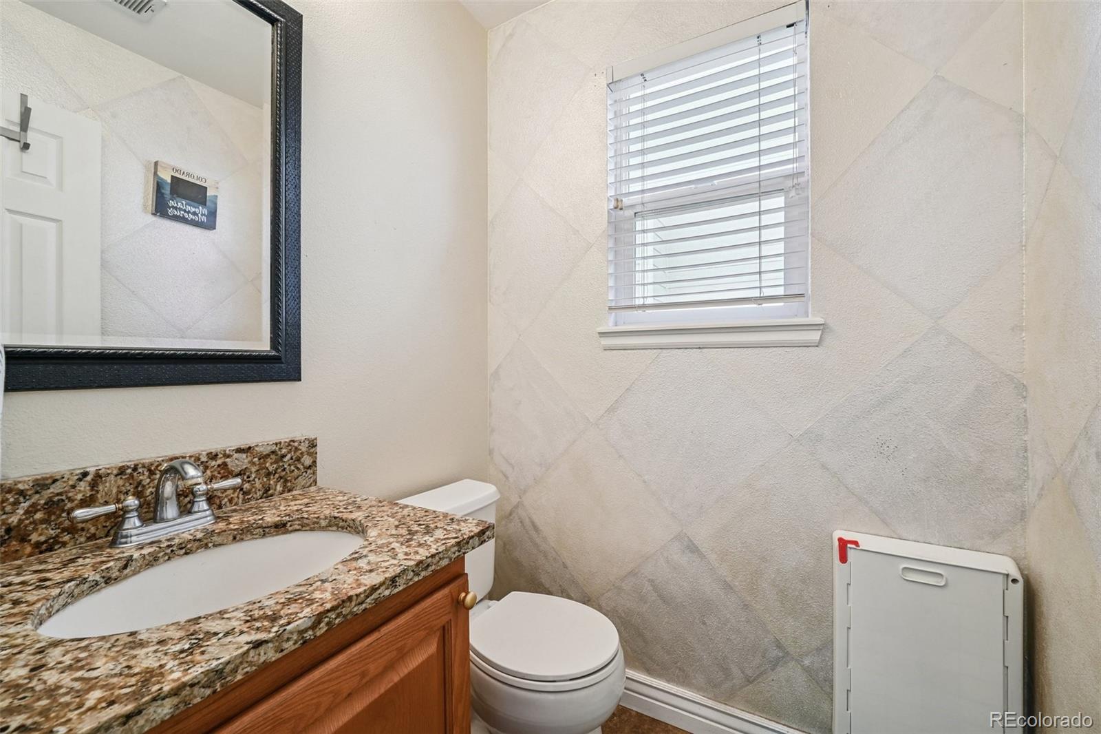 1135 Riddlewood Lane Highlands Ranch, CO 80129 - Photo 11 of 23 a bathroom with a granite countertop sink and a mirror