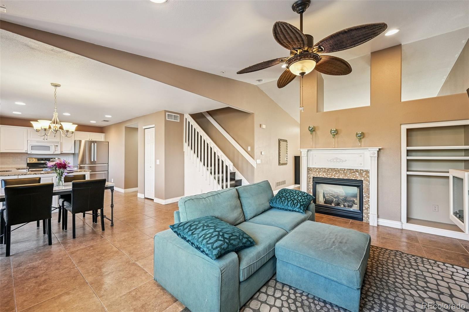 1135 Riddlewood Lane Highlands Ranch, CO 80129 - Photo 6 of 23 a living room with furniture a fireplace and a flat screen tv