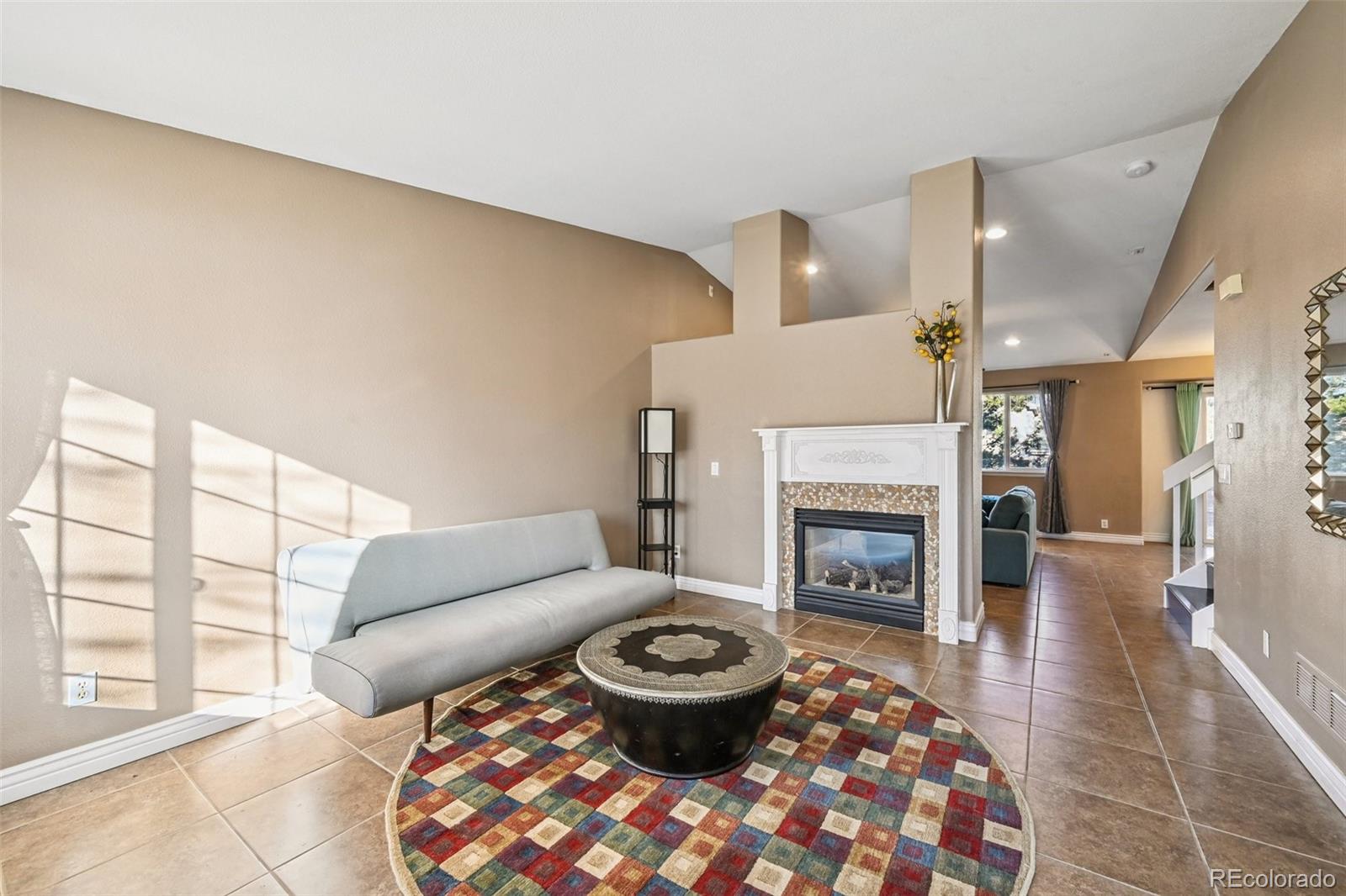 1135 Riddlewood Lane Highlands Ranch, CO 80129 - Photo 8 of 23 a living room with furniture a fireplace and a table