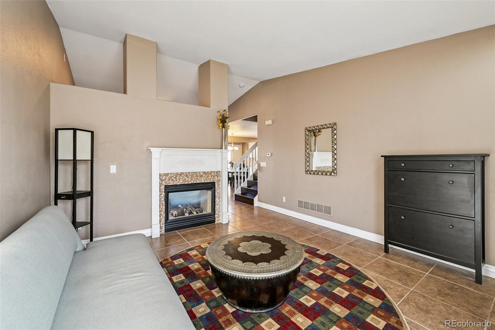 1135 Riddlewood Lane Highlands Ranch, CO 80129 - Photo 9 of 23 a living room with a fireplace and a table