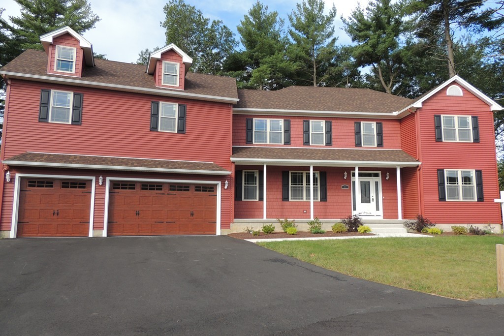 a front view of a house with garage and yard