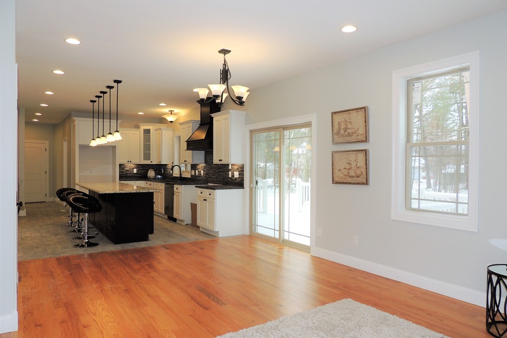 Lot 77 Alwin Place Springfield, MA 01128 - Photo 8 of 30 a kitchen with stainless steel appliances kitchen island granite countertop a refrigerator a stove a sink and a dining table with wooden floor