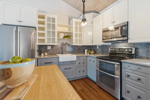 a kitchen with stainless steel appliances kitchen island granite countertop a stove a sink and a refrigerator