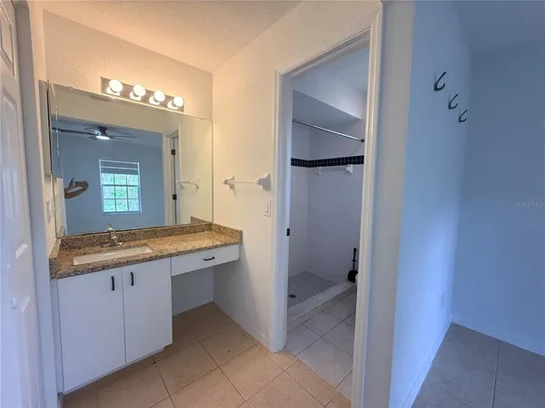 a bathroom with a granite countertop sink and a mirror