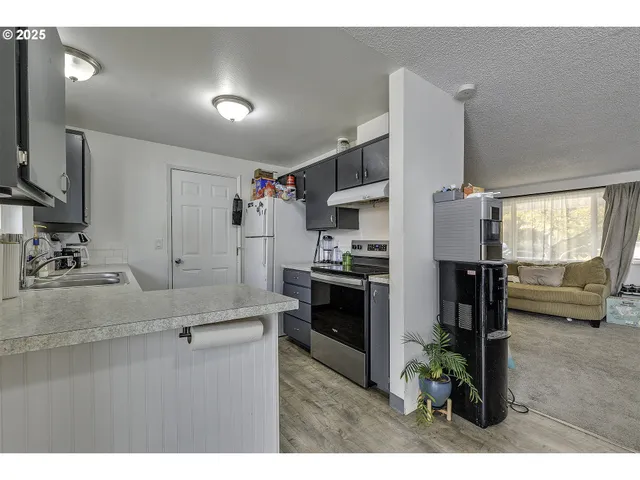 a kitchen with kitchen island white cabinets and stainless steel appliances