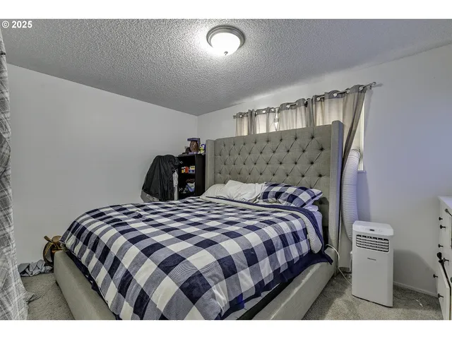 a bedroom with a bed and a lamp with the dresser