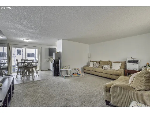 a living room with furniture and a dining table with wooden floor