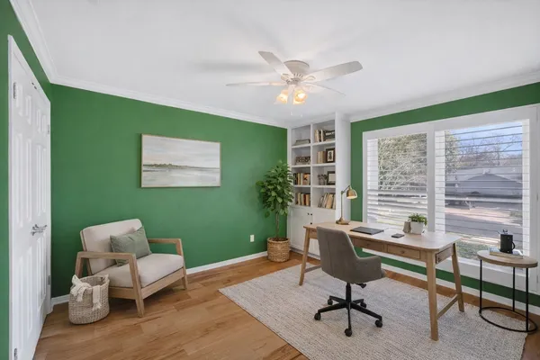 a view of a room with a large window and ceiling fan