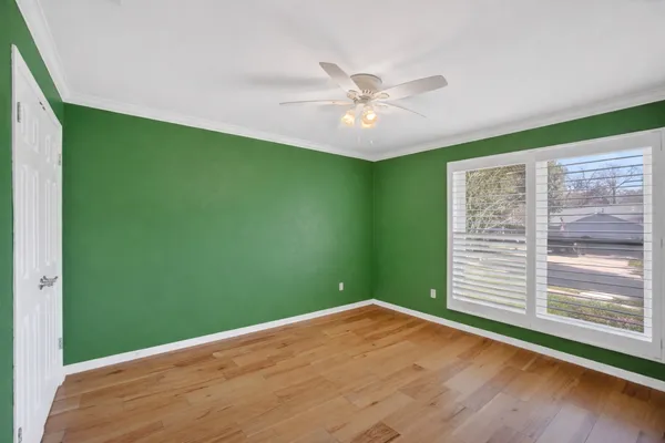 a view of an empty room with wooden floor