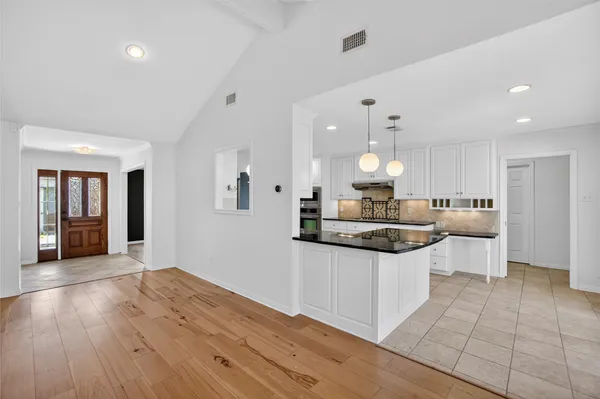 a kitchen with granite countertop a white cabinets and refrigerator
