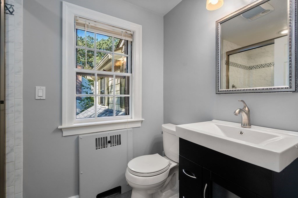 580 Quinobequin Road Newton, MA 02468 - Photo 14 of 25 a bathroom with a toilet sink and mirror