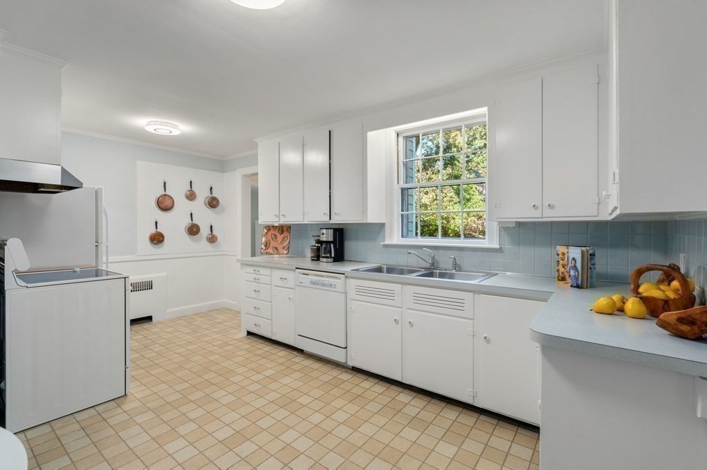 580 Quinobequin Road Newton, MA 02468 - Photo 6 of 25 a kitchen with a sink window and cabinets
