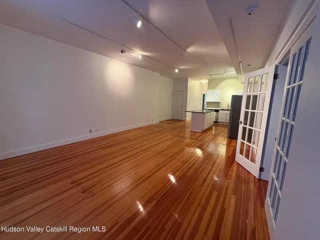 a view of empty room with wooden floor