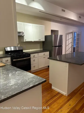 a kitchen with stainless steel appliances granite countertop a refrigerator and a sink