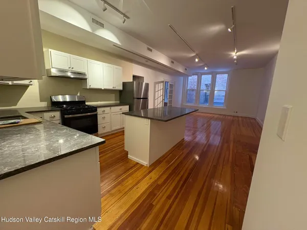 a kitchen with a sink stainless steel appliances furniture and a window