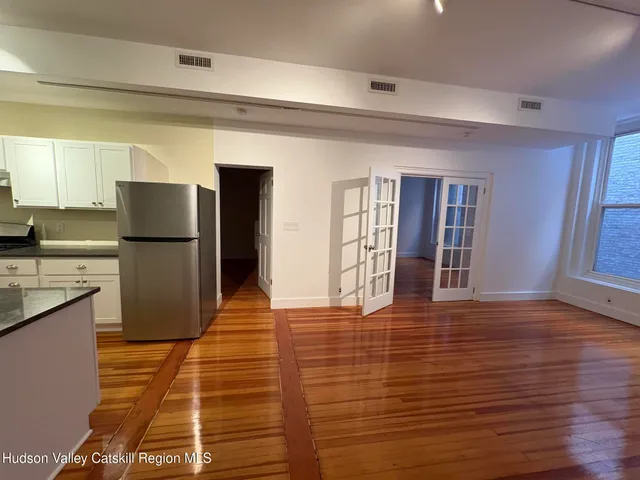 a view of a kitchen with wooden floor and a refrigerator