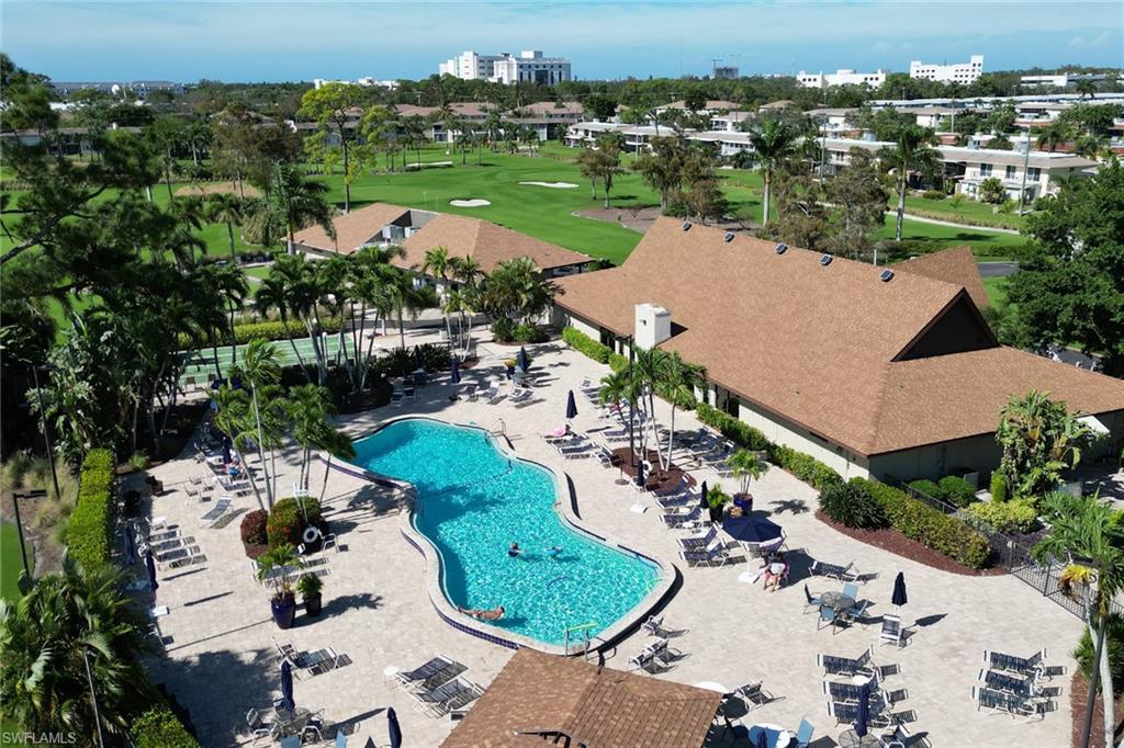 186 Harrison Road, Unit H4 Naples, FL 34112 - Photo 16 of 34 Main Community pool featuring a patio area and golf course view of the Palmetto. The community has 9 other section pools.